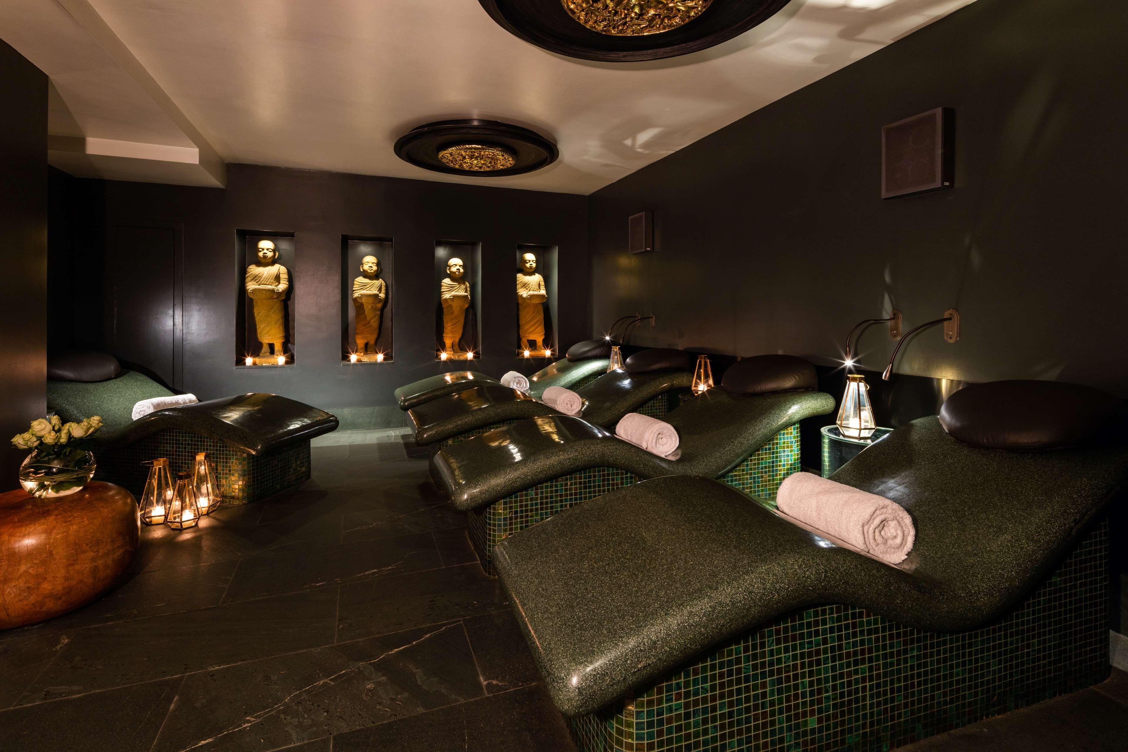 The May Fair, A Radisson Collection Hotel, Mayfair Londres Extérieur photo The photo shows a tranquil spa environment. It features lounge chairs with curved backs, designed for relaxation, positioned in a dimly lit room. The walls are decorated in dark tones, providing a calming atmosphere. There are illuminated statues or 